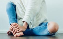 A tired nurse massaging her feet after a long shift